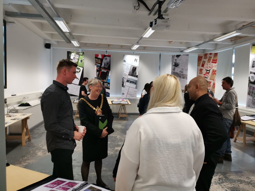 Entrepreneur Dan pitches his new city brand to the Mayor of Wolverhampton during the degree show private view